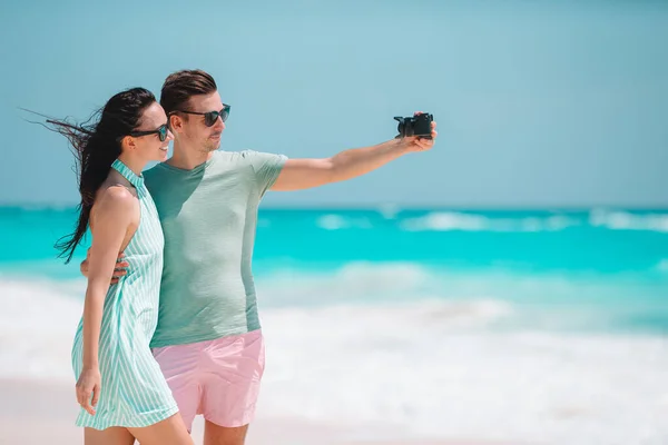 Pareja feliz tomando una foto en la playa blanca en vacaciones de luna de miel — Foto de Stock