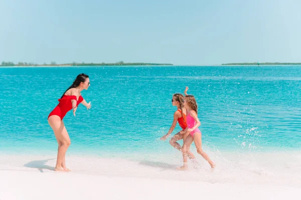 Adorables petites filles et jeune mère sur la plage blanche tropicale — Photo