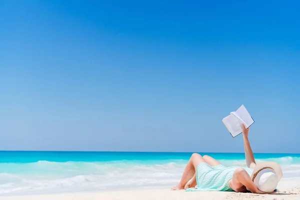 Giovane donna che legge libro durante la spiaggia tropicale bianca — Foto Stock