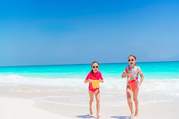 Küçük mutlu komik kızlar tropikal plajda birlikte oynarken çok eğlenirler.. — Stok fotoğraf