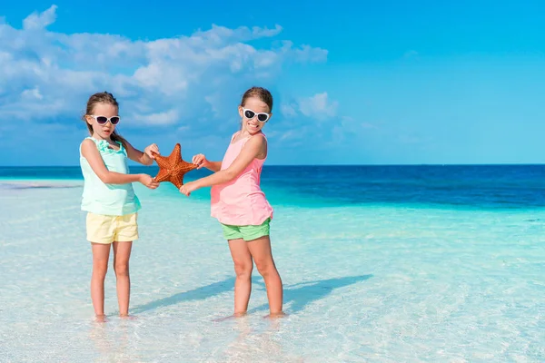 İki küçük mutlu kız tropikal plajda birlikte oynarken çok eğleniyor. — Stok fotoğraf