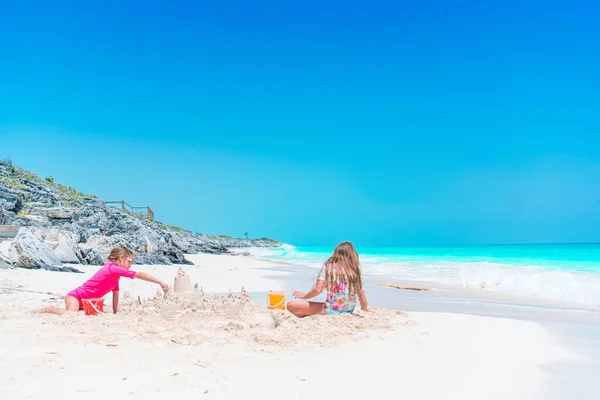 Deux petites filles heureuses ont beaucoup de plaisir à la plage tropicale en jouant ensemble — Photo