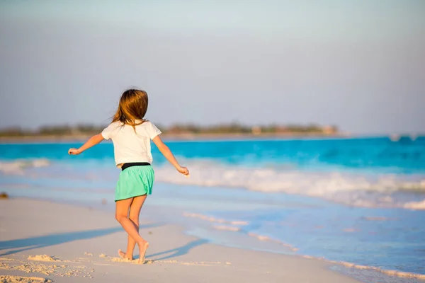 Söt liten flicka på stranden har mycket roligt i grunt vatten — Stockfoto