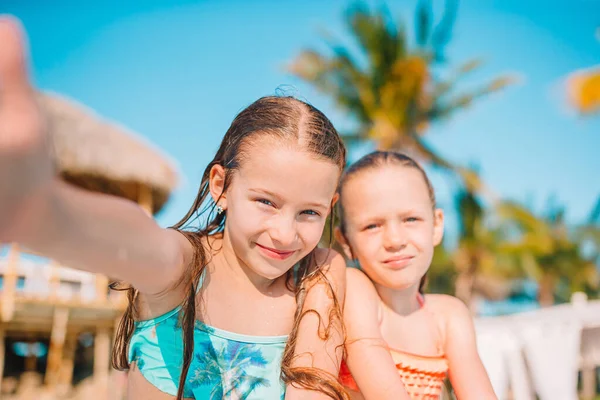 Adoráveis meninas brincando na piscina ao ar livre em férias — Fotografia de Stock