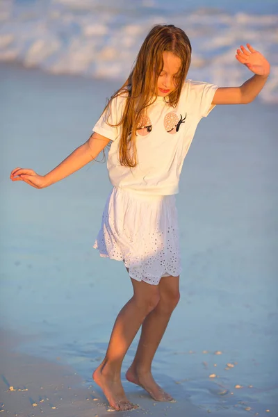 해변에 사는 사랑 스러운 어린 소녀는 얕은 물에서 재미있게 놀고 있다 — 스톡 사진
