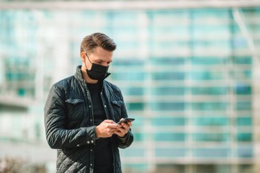 Modern bir binanın arka planında maske takan adam.,