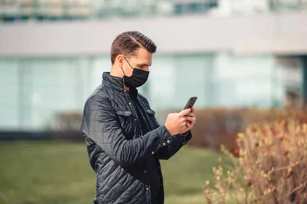 Man met een masker op een achtergrond van een modern gebouw, — Stockfoto