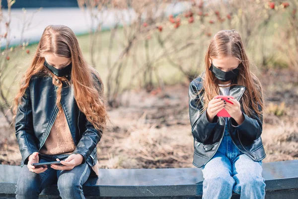 Flickor bär mask på en bakgrund av en modern byggnad, — Stockfoto