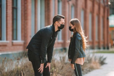 Modern bir binanın arka planında maske takan insanlar.,