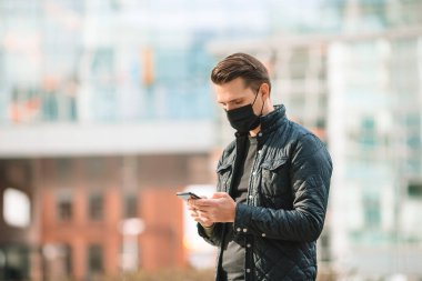Modern bir binanın arka planında maske takan adam.,