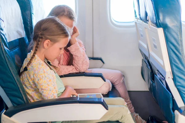 Schattige kleine meisjes die met een vliegtuig reizen. — Stockfoto
