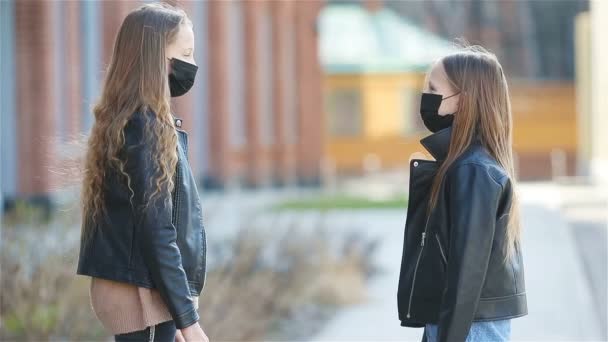 Maszkot viselő lányok egy modern épület hátterében, — Stock videók