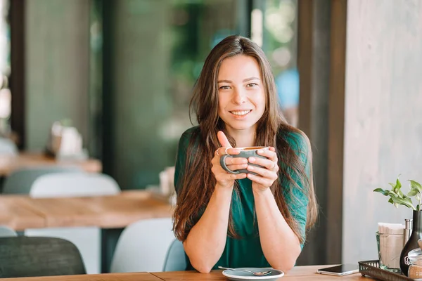 Красивая женщина завтракает в кафе. Счастливая городская женщина пьет кофе — стоковое фото