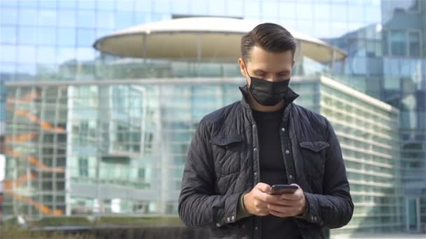 Hombre usando una máscara sobre un fondo de un edificio moderno, — Vídeo de stock