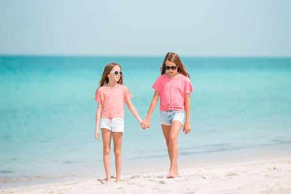 Маленькие девочки веселятся на тропическом пляже, играя вместе на мелководье — стоковое фото