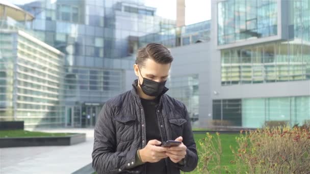 Homem usando uma máscara em um fundo de um edifício moderno, — Vídeo de Stock