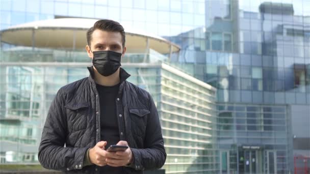 Hombre usando una máscara sobre un fondo de un edificio moderno, — Vídeo de stock