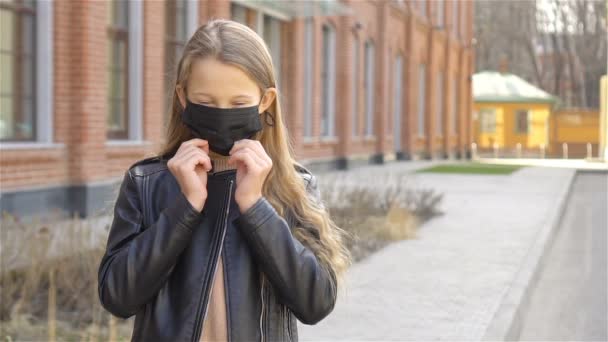 マスクを身に着けている女の子はコロナウイルスやグリップから保護します — ストック動画