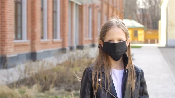 Flicka klädd i en mask skyddar mot Coronavirus och gripp — Stockvideo