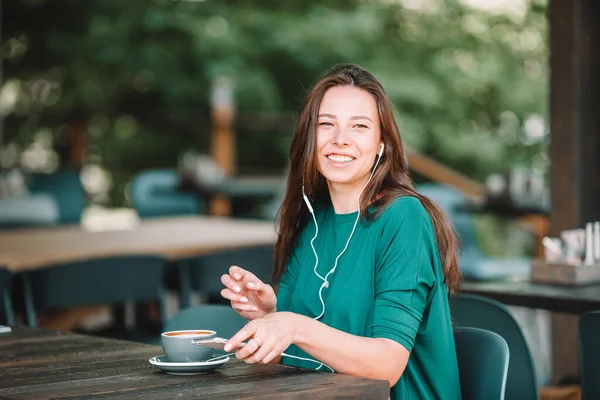Schöne Frau beim Frühstück im Café im Freien. Glückliche junge Stadtfrau trinkt Kaffee — Stockfoto