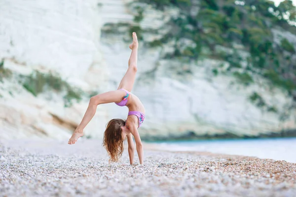 Живая активная девочка на пляже во время летних каникул — стоковое фото