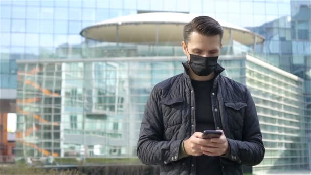 Hombre usando una máscara sobre un fondo de un edificio moderno, — Vídeos de Stock