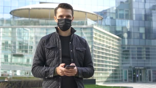 Hombre usando una máscara sobre un fondo de un edificio moderno, — Vídeo de stock