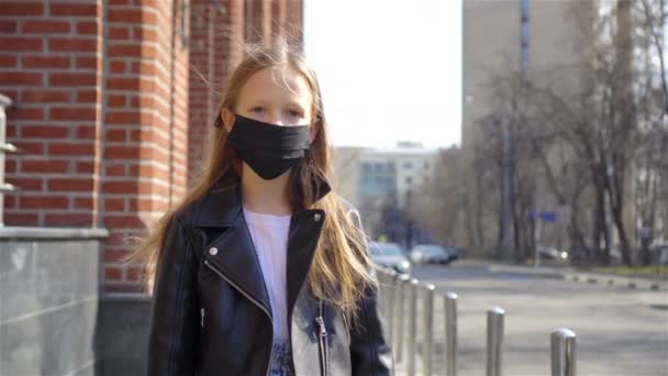 Menina vestindo uma máscara proteger contra o Coronavirus e agarrar — Vídeo de Stock