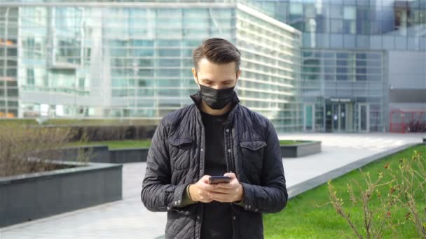 Hombre usando una máscara sobre un fondo de un edificio moderno, — Vídeos de Stock