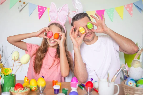 Ojciec i jego córeczka malują jajka. Szczęśliwa rodzina przygotowuje się do Wielkanocy. — Zdjęcie stockowe