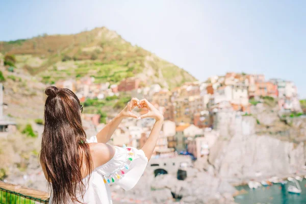 Happy girl podejmowania z rąk kształt serca na starej nadmorskiej miejscowości w Parku Narodowym Cinque Terre. — Zdjęcie stockowe