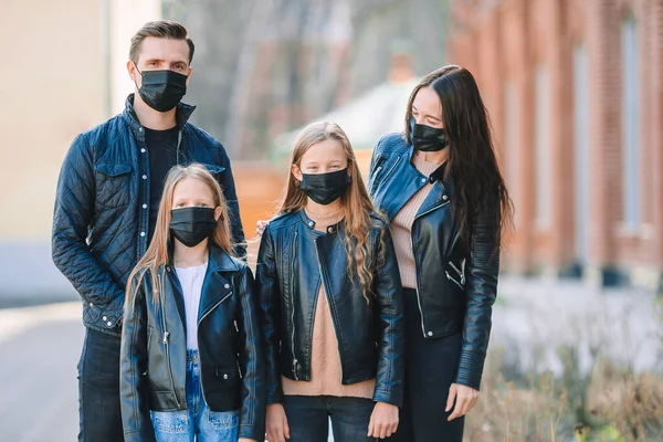 Family wearing a mask on a background of a modern building,