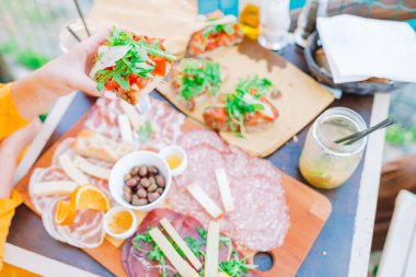 Manarola manzaralı açık kafede taze bruschettes, peynir ve et var.