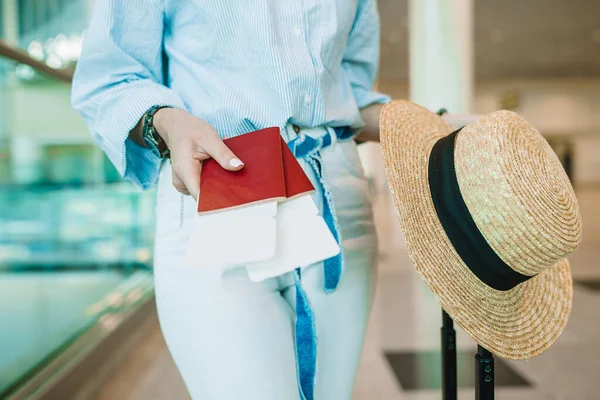 Close-up de passaportes e cartão de embarque em mãos femininas no aeroporto — Fotografia de Stock