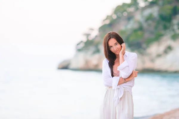 Mujer tendida en la playa disfrutando de vacaciones de verano — Foto de Stock