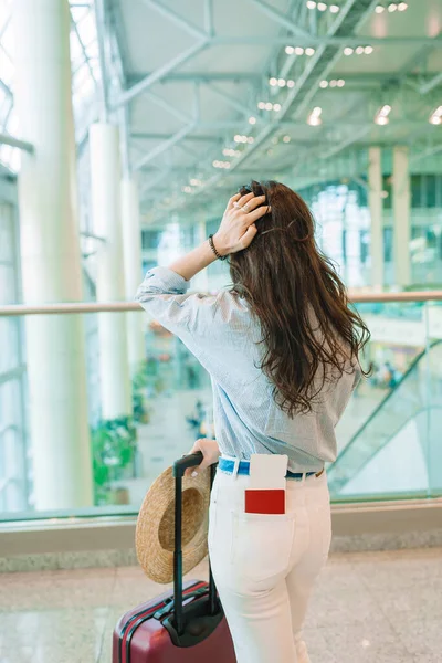 Giovane donna in cappello con bagaglio in aeroporto internazionale a piedi con i suoi bagagli . — Foto Stock