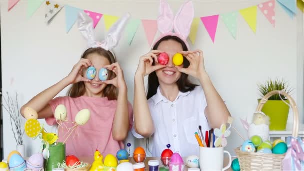 妈妈和她的小女儿画鸡蛋。快乐的家庭为复活节做准备. — 图库视频影像