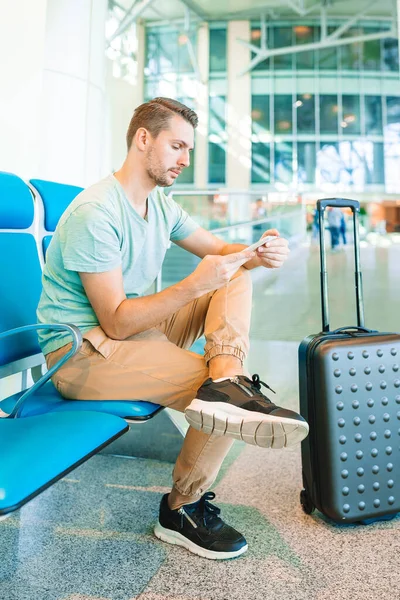 Junger Mann wartet in Flughafen-Lounge auf Flugzeug. — Stockfoto