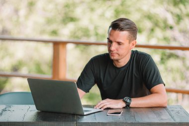 Bilgisayarlı genç adam evde çalışıyor.