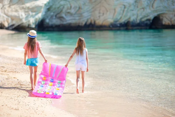 Маленькі дівчата розважаються на тропічному пляжі, граючи разом на мілководді — стокове фото