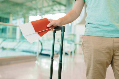 Havaalanında pasaportlu ve biniş kartlı bir adam var.