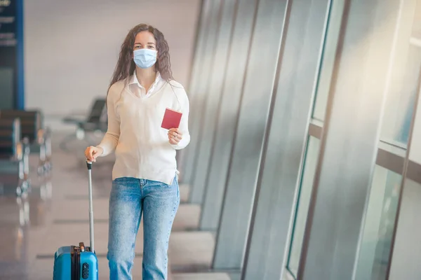 Giovane donna con bagagli in aeroporto internazionale. Passeggero di una compagnia aerea in una lounge dell'aeroporto in attesa di un aereo di volo — Foto Stock