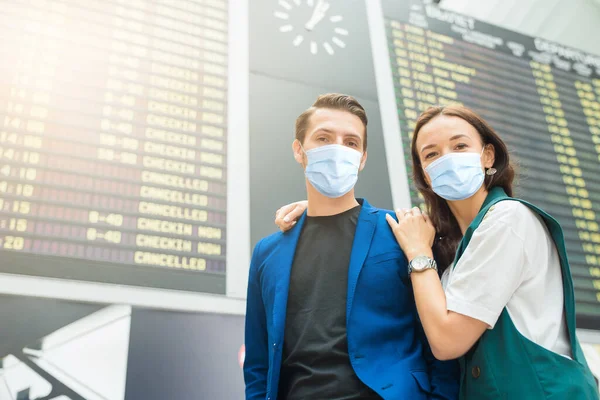 Młoda para na międzynarodowym lotnisku patrząc na tablicy informacyjnej lotu — Zdjęcie stockowe