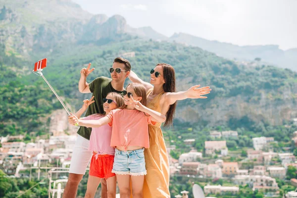 Pais e filhos tirando selfie foto fundo Positano cidade em Itali, na costa de Amalfi — Fotografia de Stock