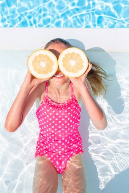 Yüzme havuzunda yüzen sevimli küçük kız.