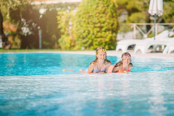 Adorables niñas jugando en la piscina al aire libre de vacaciones —  Fotos de Stock