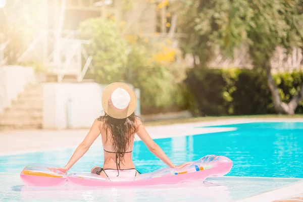 Schöne junge Frau entspannt sich im Schwimmbad. — Stockfoto