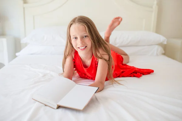Schattig klein meisje doet huiswerk op laptop — Stockfoto