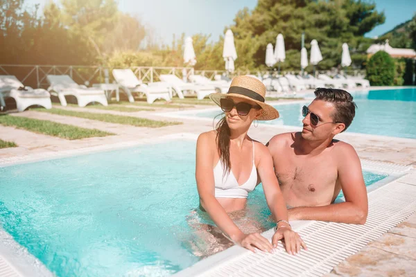 Cheerful couple resting in a swimming pool — Stock Photo, Image