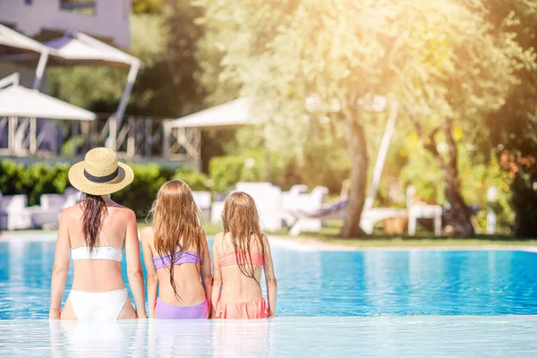 Mãe e duas crianças desfrutando de férias de verão na piscina de luxo — Fotografia de Stock
